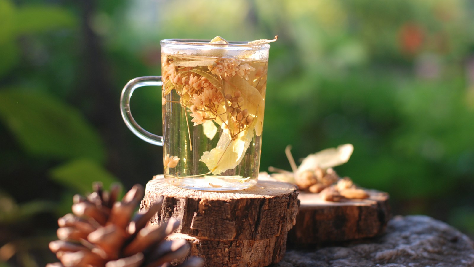 Glass mug of amber tea on a wooden surface