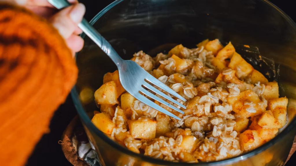Warm apple crumble being served with a fork