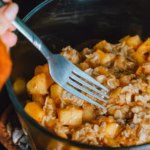 Warm apple crumble being served with a fork