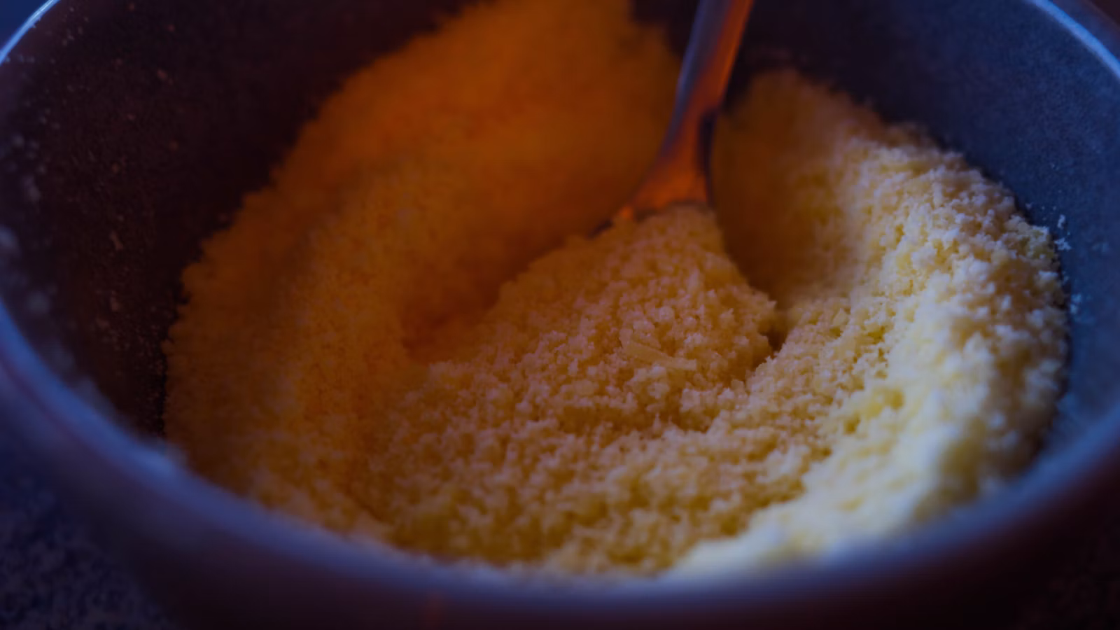 A warm grain dish served in a bowl with a spoon