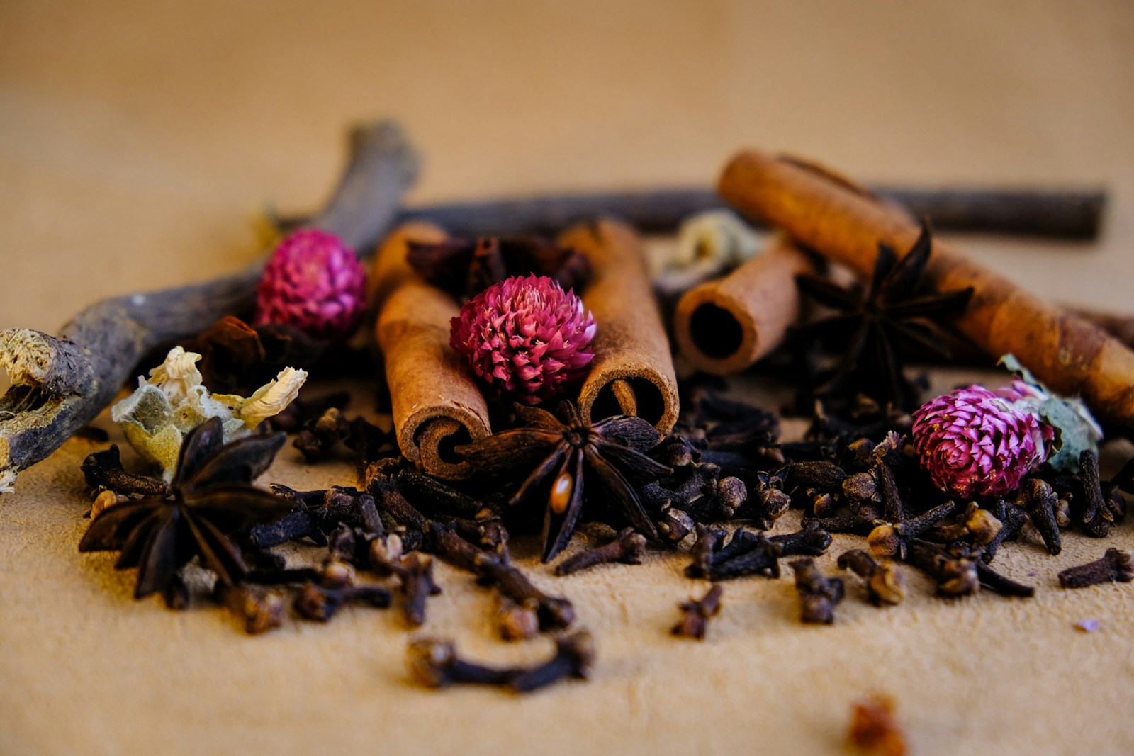 Cloves arranged with cinnamon, star anise, and dried flowers