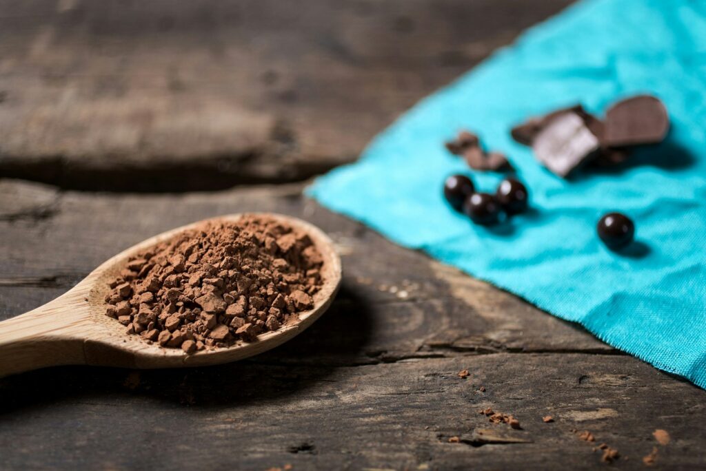 Cocoa powder in a wooden spoon with chocolate