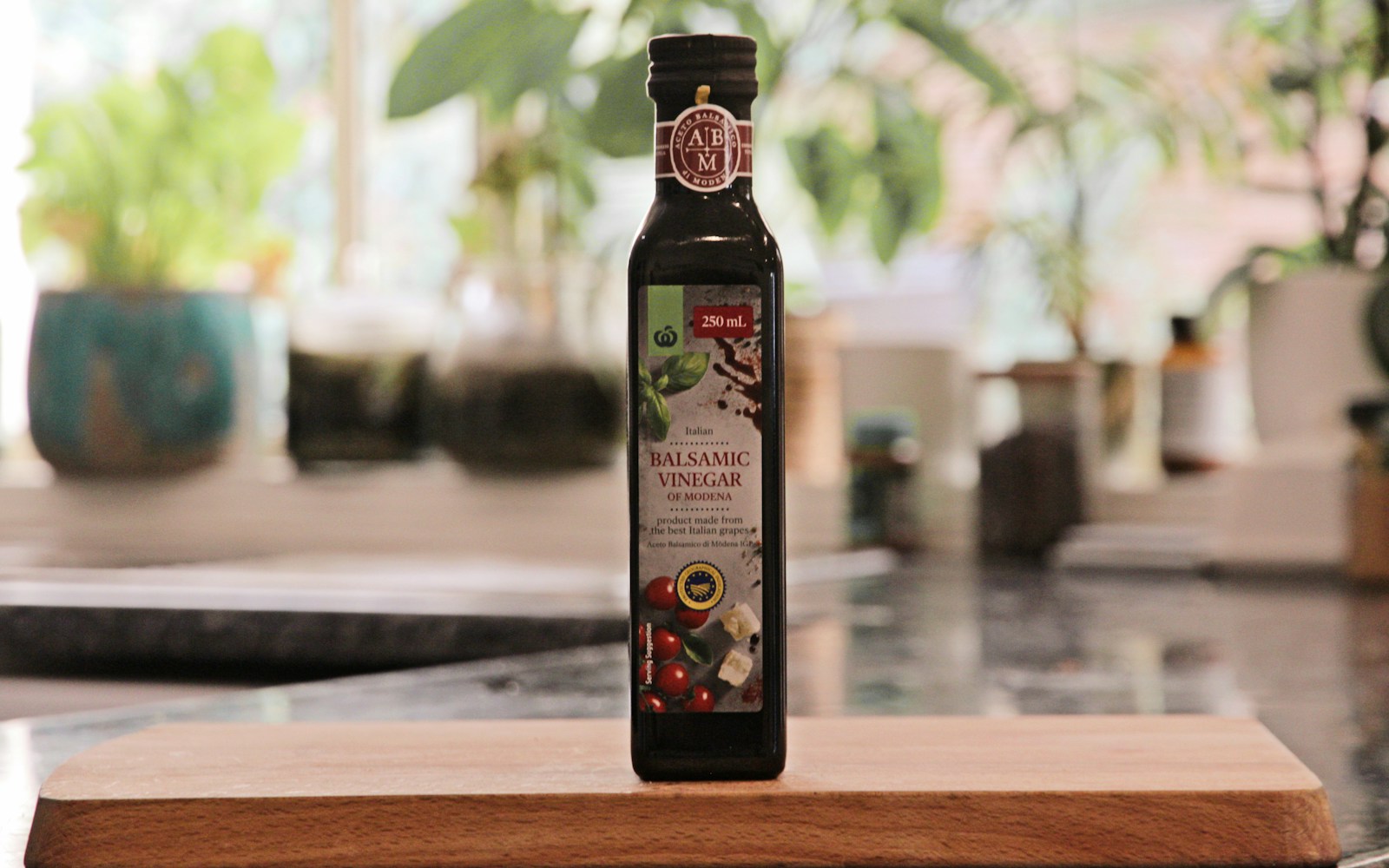 Glass bottle of cooking oil on a wooden cutting board