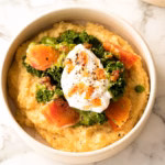 Creamy yellow polenta topped with a poached egg and greens