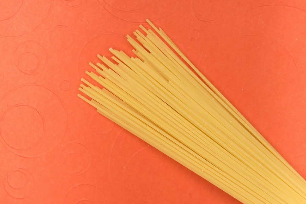 Bundle of dry golden spaghetti on a kitchen surface