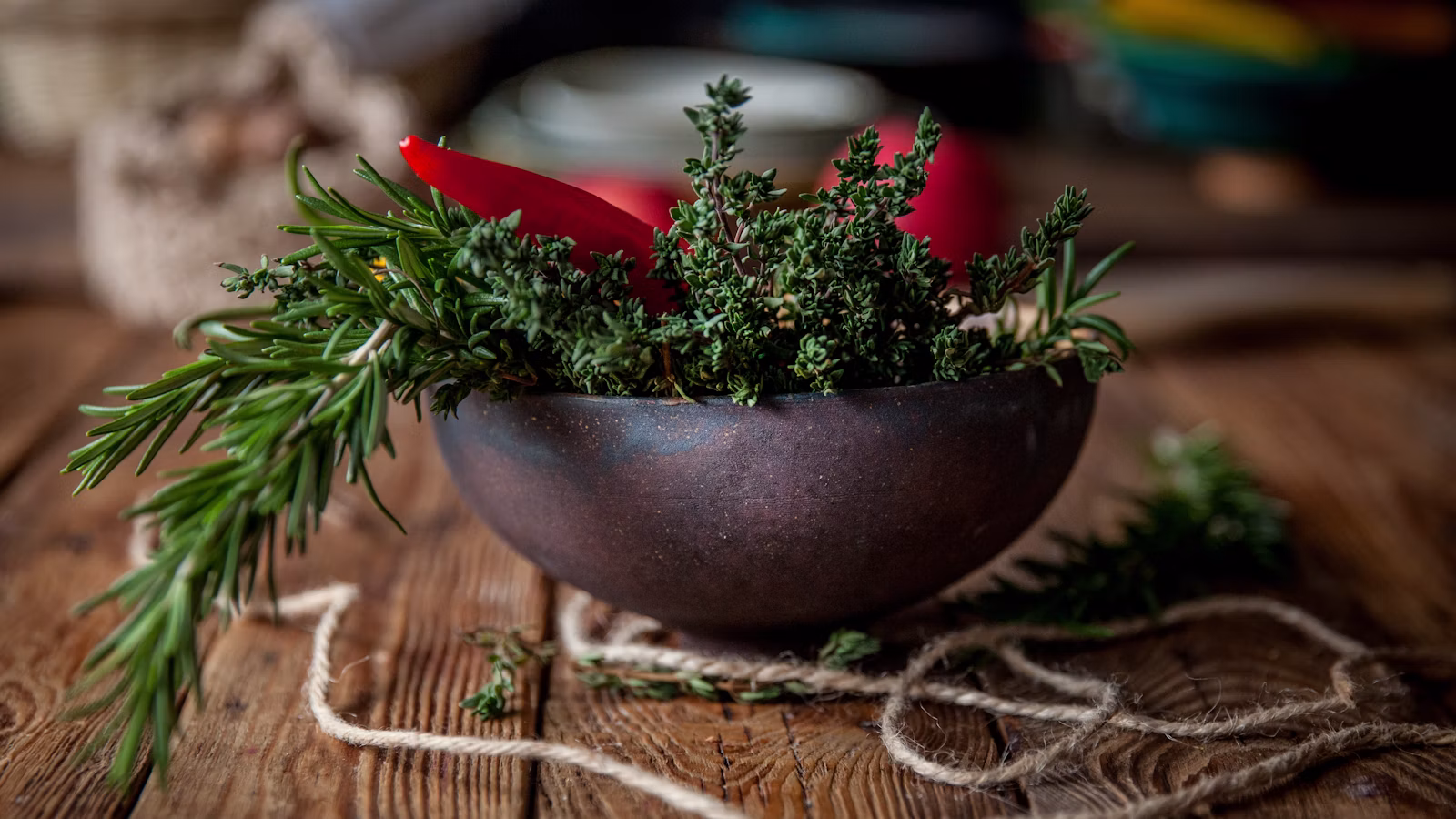 Fresh red chili peppers and herbs in a bowl