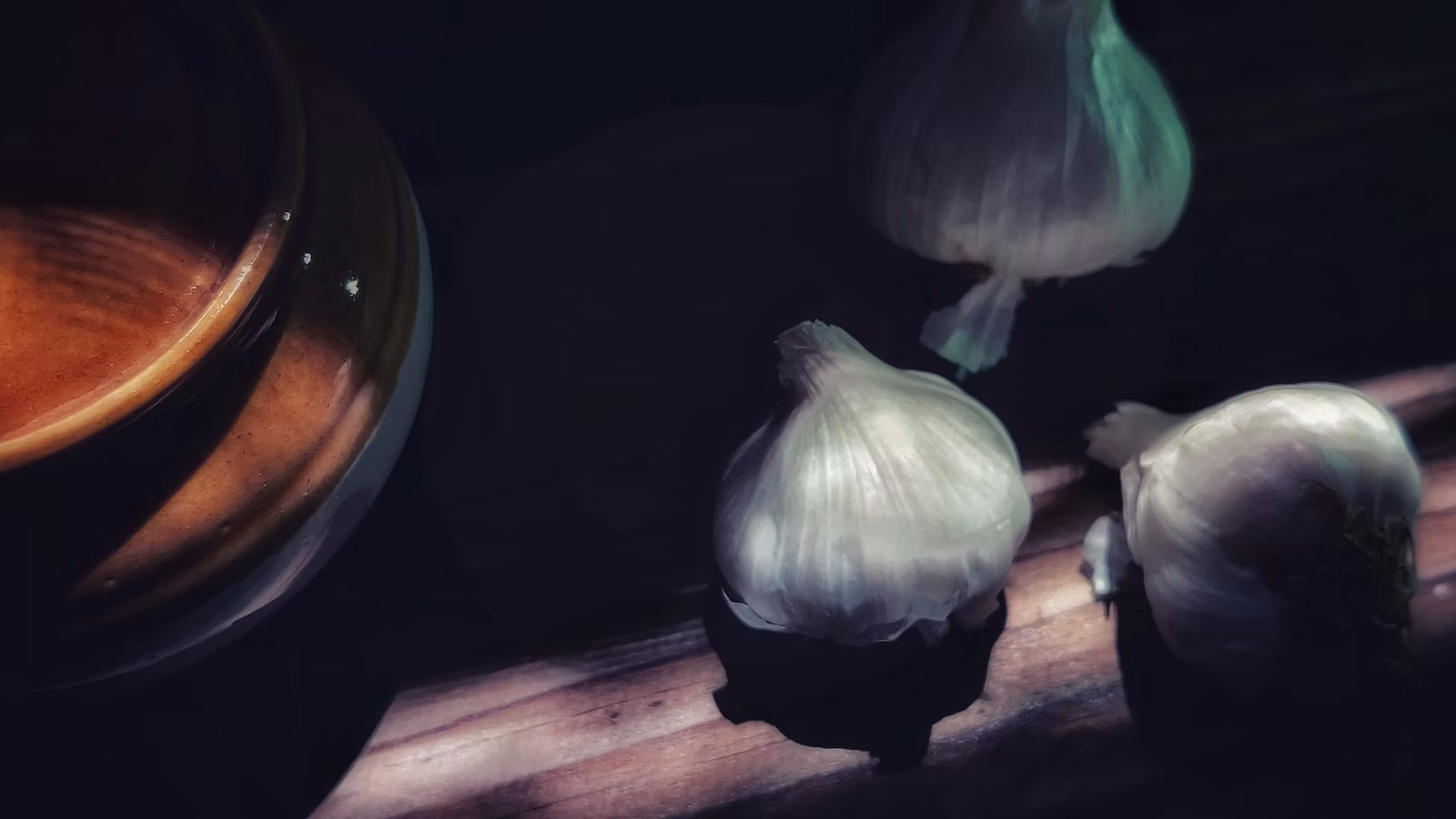 Whole garlic bulbs and cloves on a wooden table