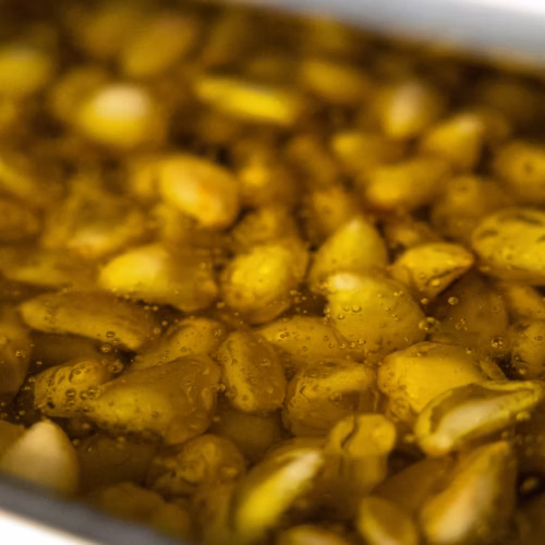 Tender garlic cloves cooking slowly in oil