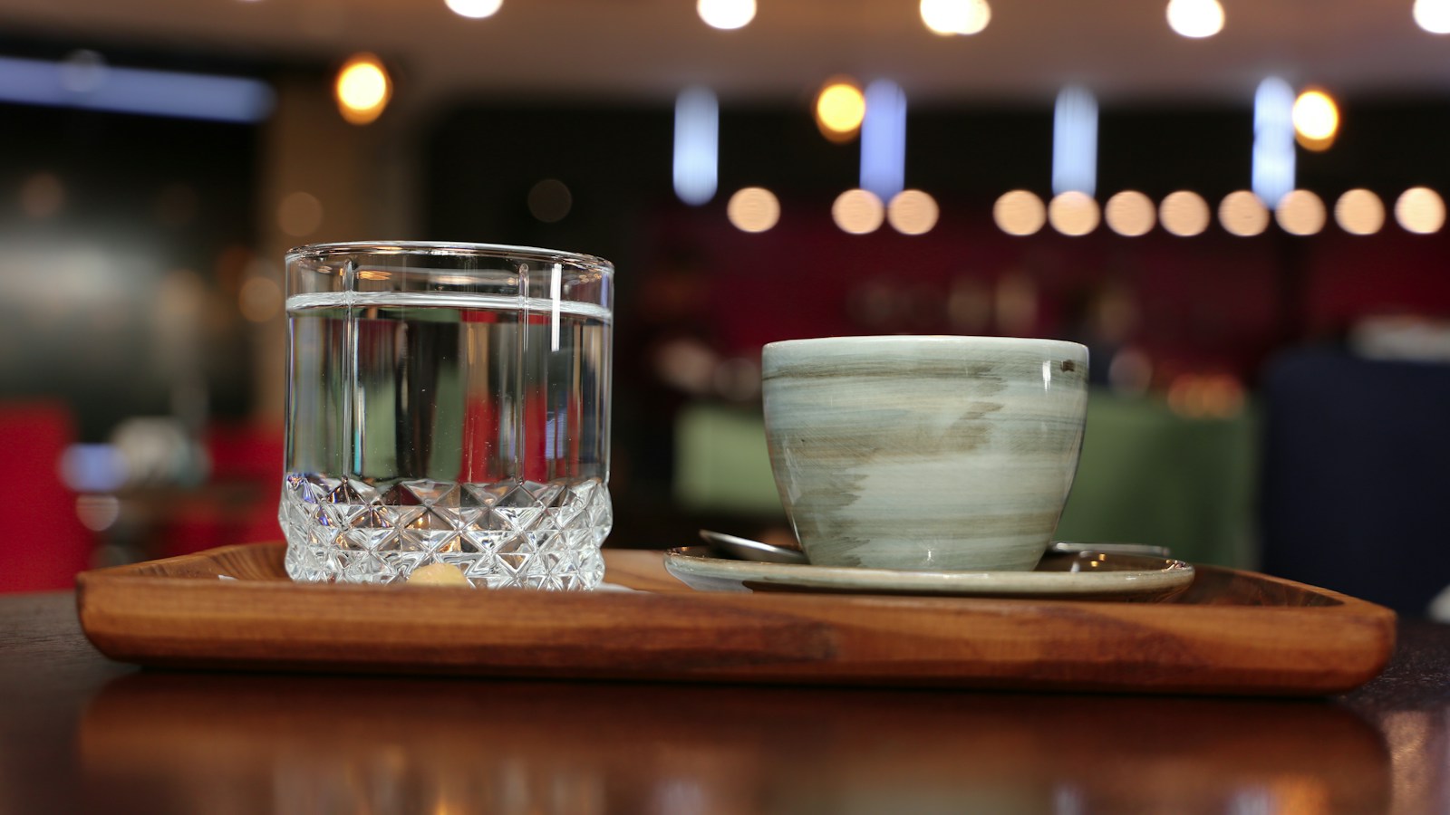 Glass of water on a wooden tray