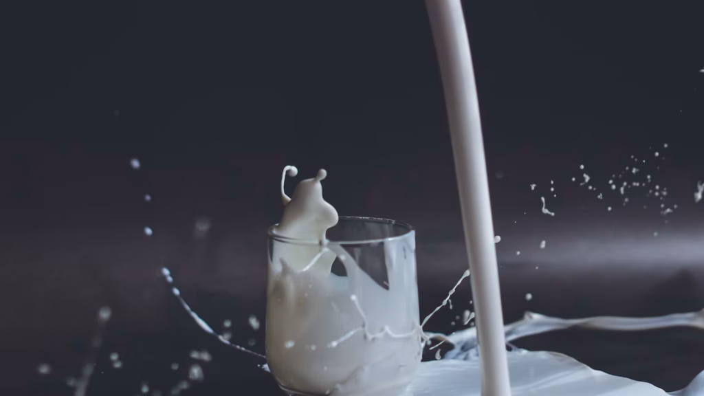 Fresh cultured milk splashing into a clear glass