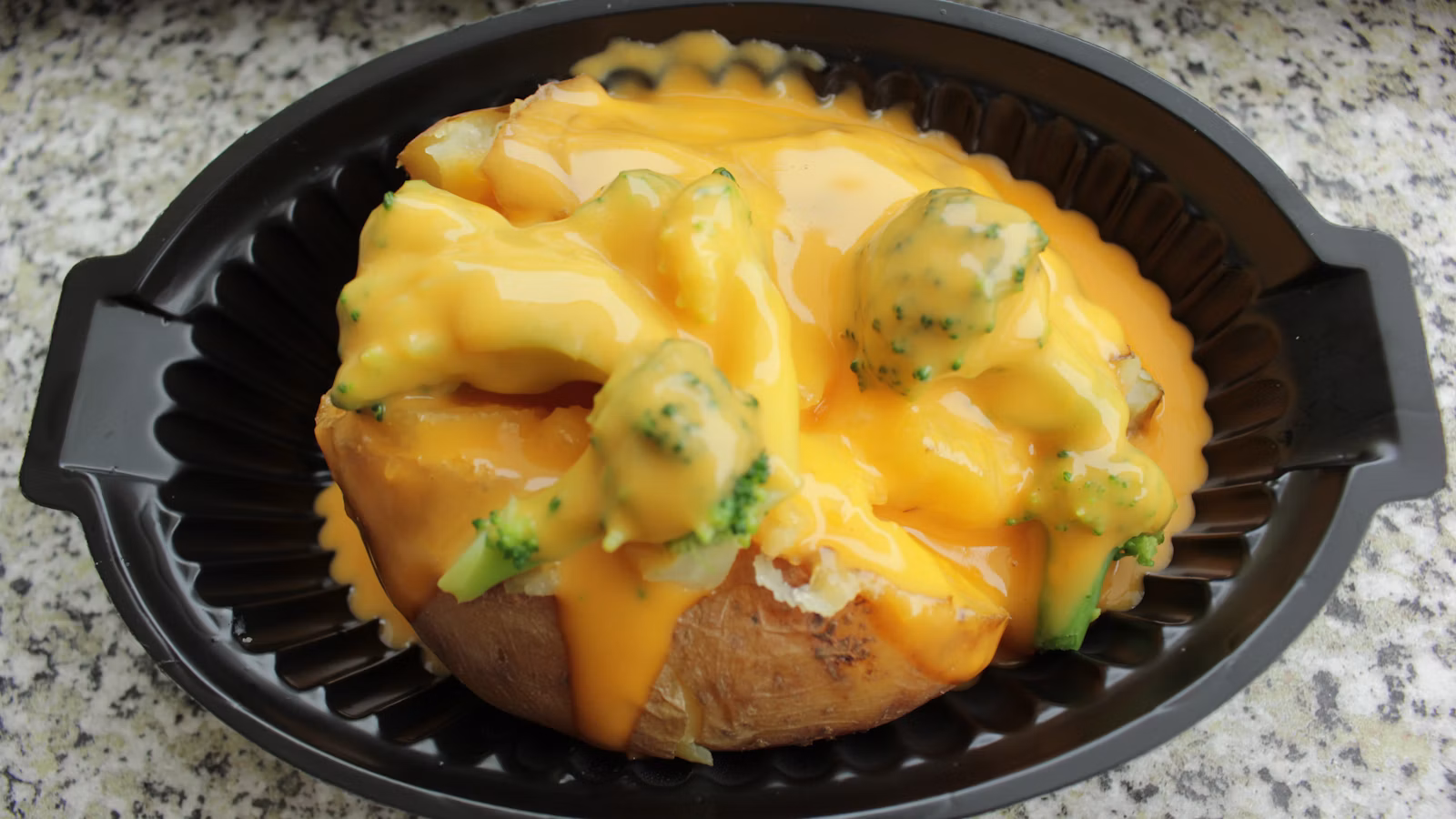 Baked potato topped with cheese and broccoli