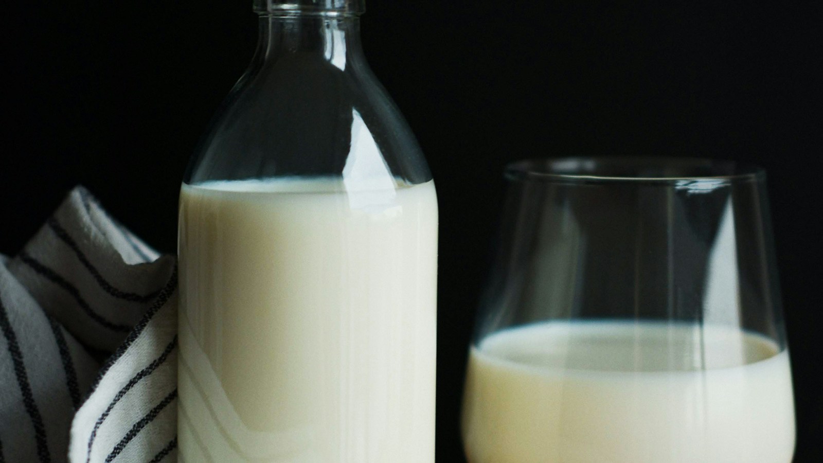 Bottle and glass of milk beside cookies