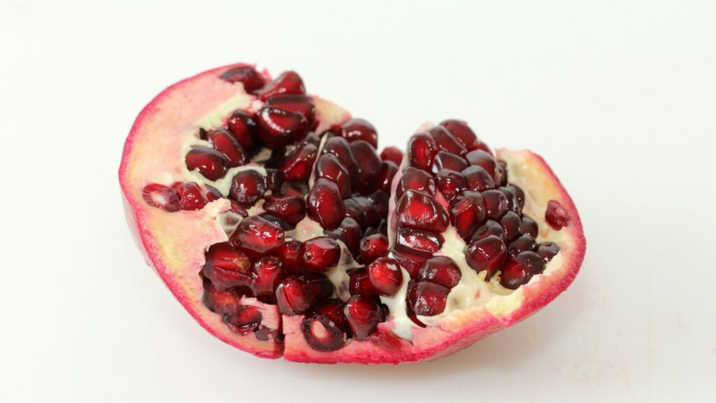 Cut pomegranate showing red seeds and pale membranes