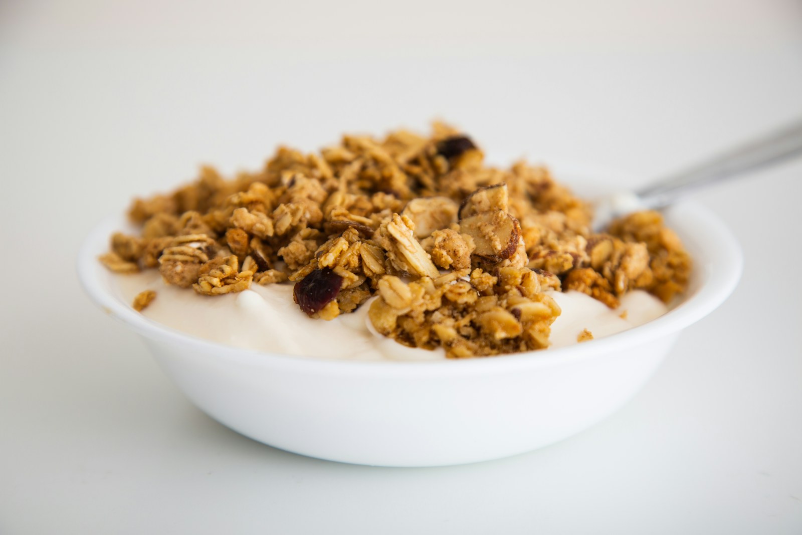 Plain yogurt with granola and spoon