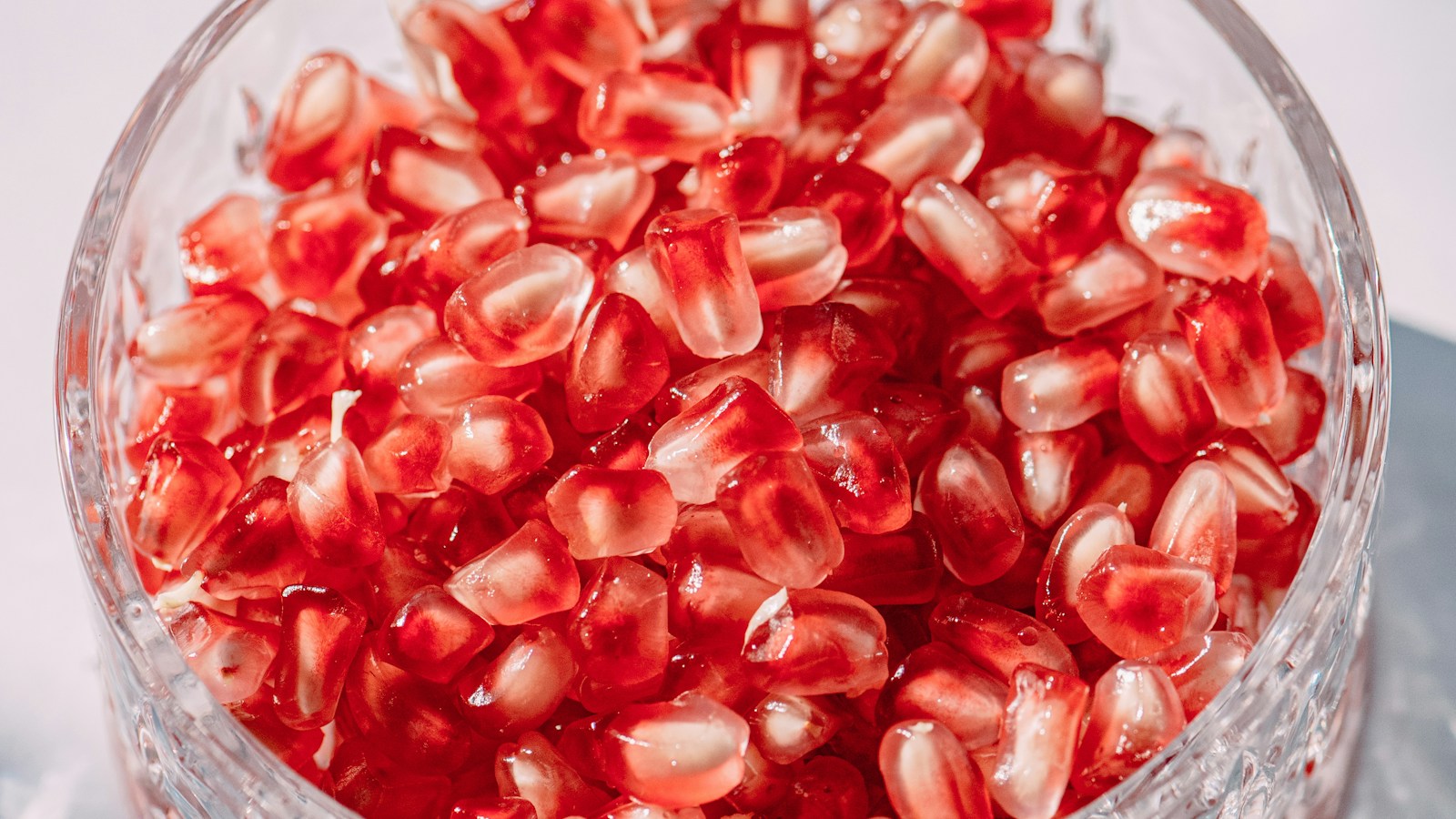 Pomegranate seeds in a clear glass bowl