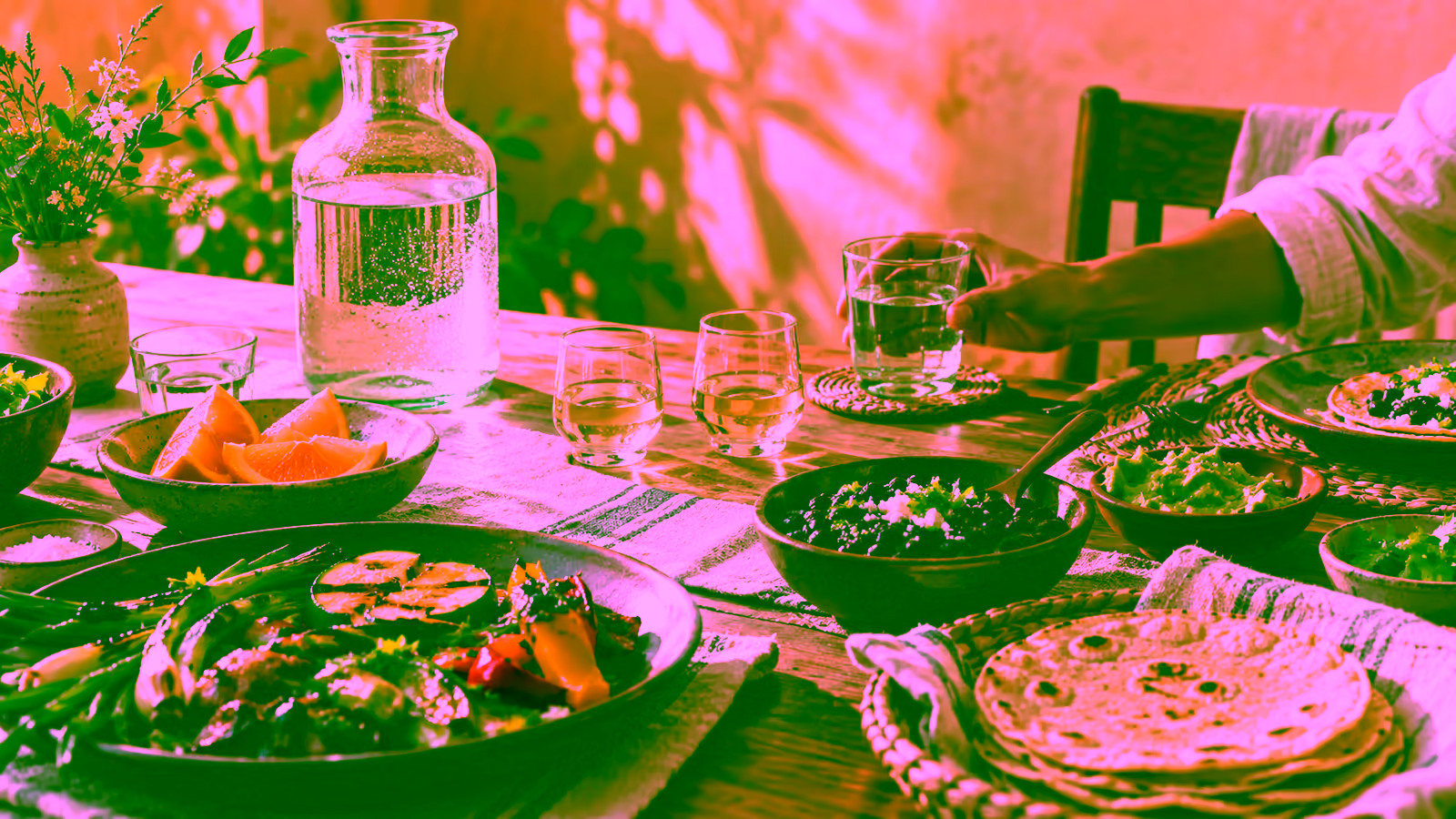 A modest agave-spirit tasting with water, orange slices, small glasses, and a bowl of food