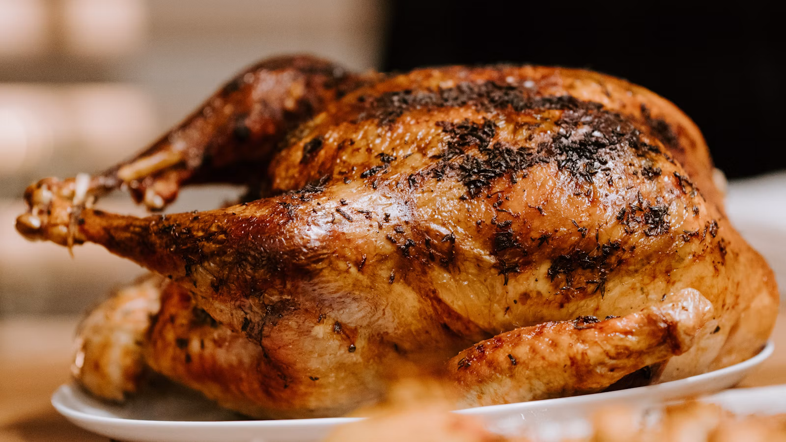 Roasted poultry presented with herbs on a white platter