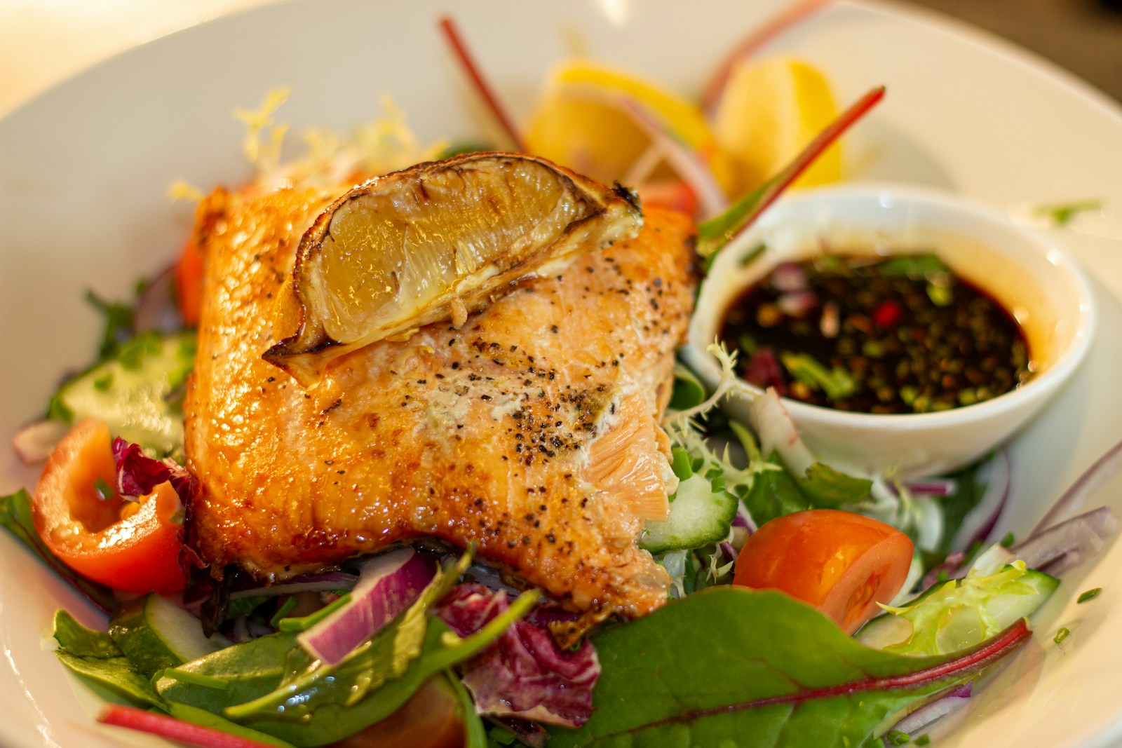 Salmon served over a fresh green salad