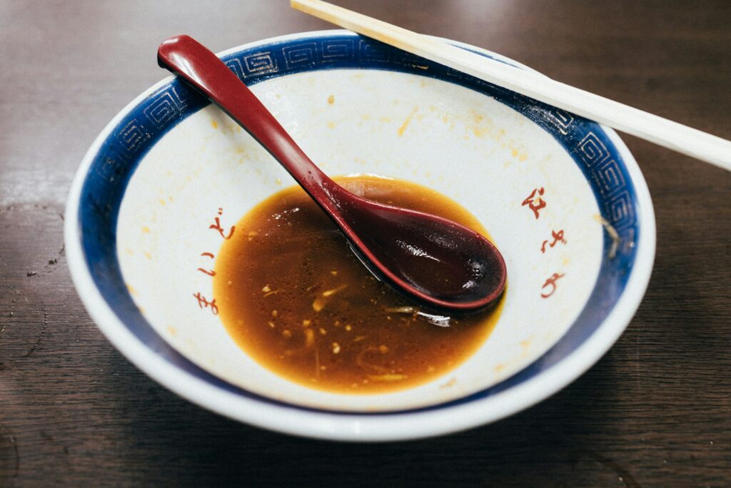 Small bowl of dark savory sauce with a spoon