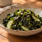 Japanese seaweed salad with cucumber, scallions, and sesame in a ceramic bowl
