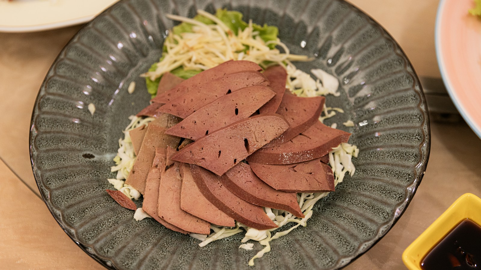 Sliced cooked liver with cabbage garnish