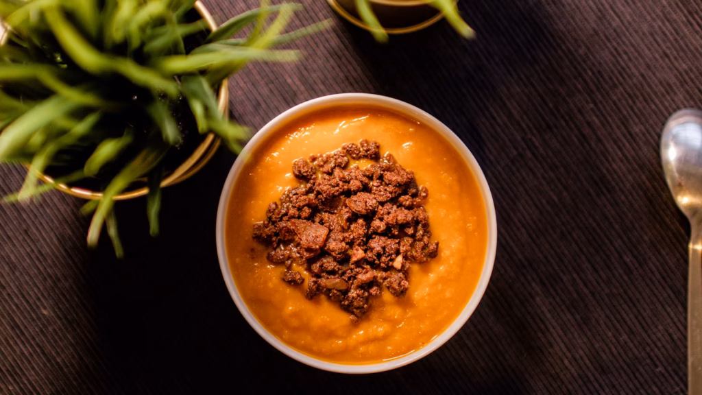 Smooth orange puree served in a white bowl