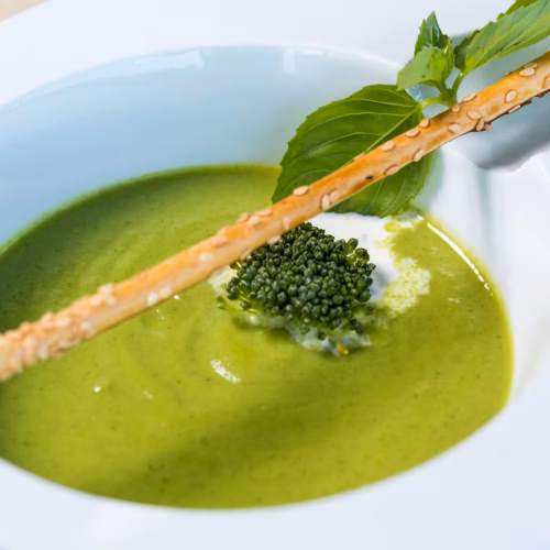 Thick green split pea soup served in a white bowl