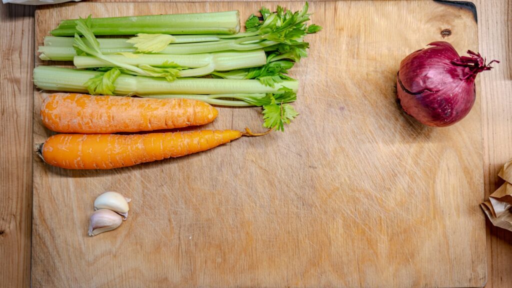 Celery carrots onion and garlic on a cutting board