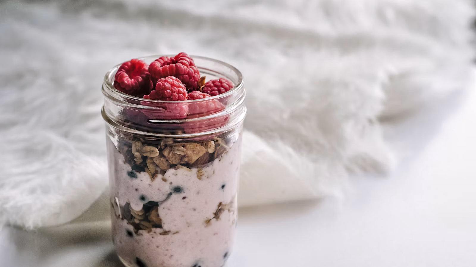 Layered yogurt, granola, and fruit in a glass jar