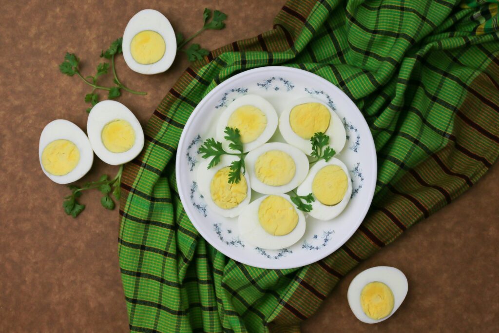 Sliced hard-boiled eggs with parsley on a white plate
