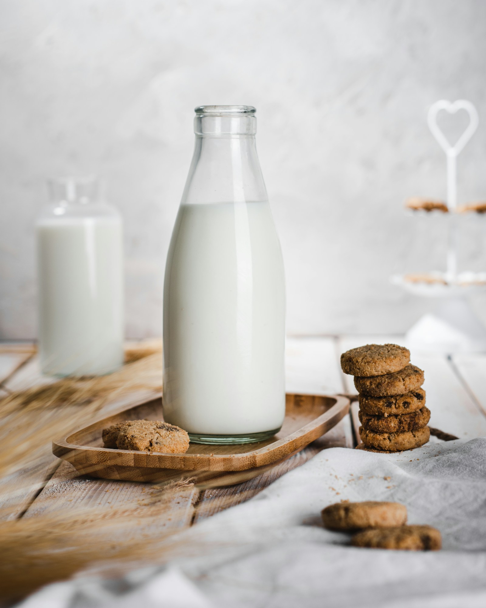 A bottle of milk beside cookies on a table