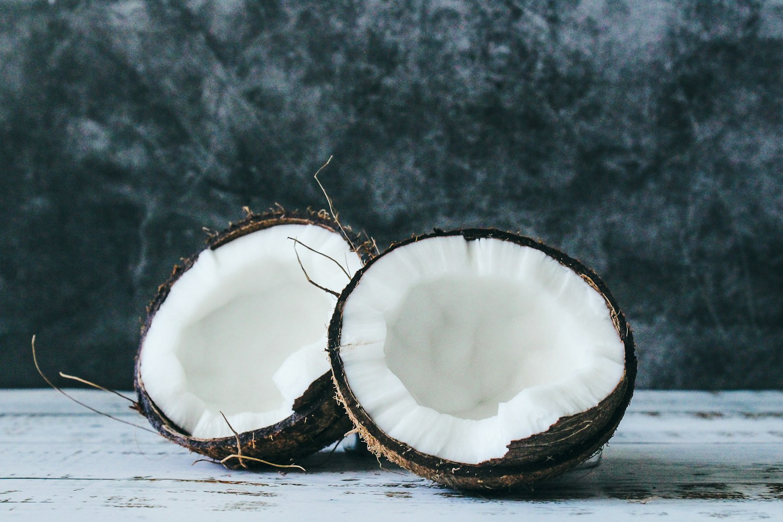 Two coconut halves showing their white flesh