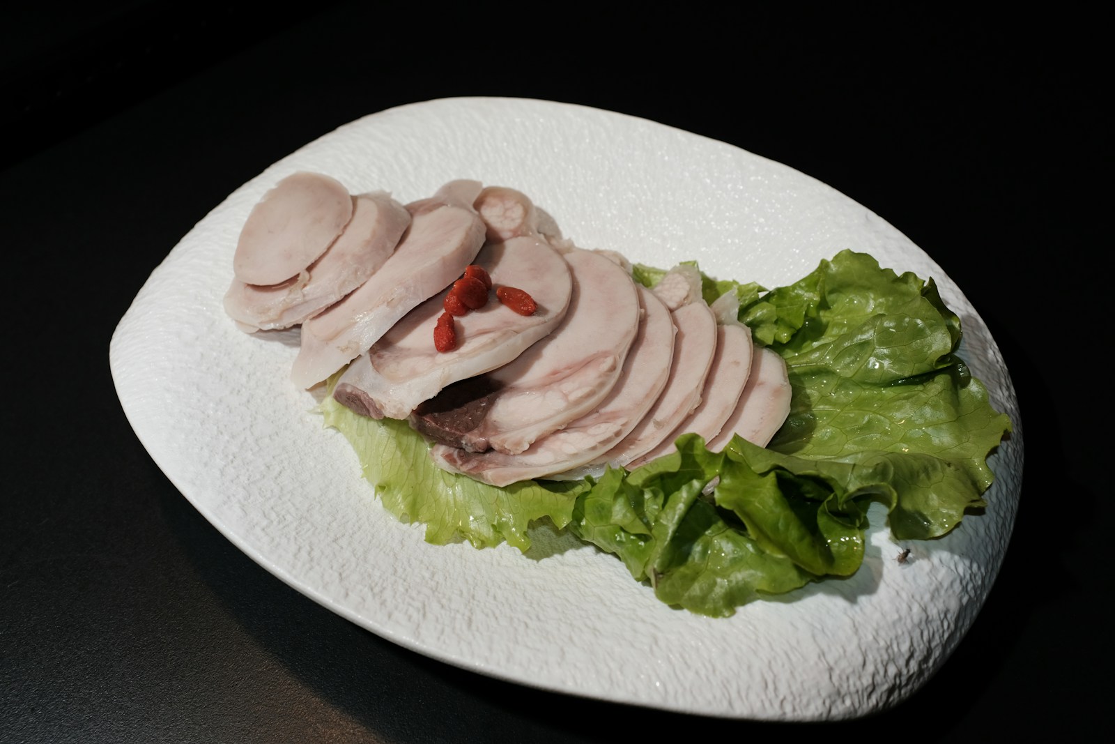 Slices of cooked poultry arranged over lettuce