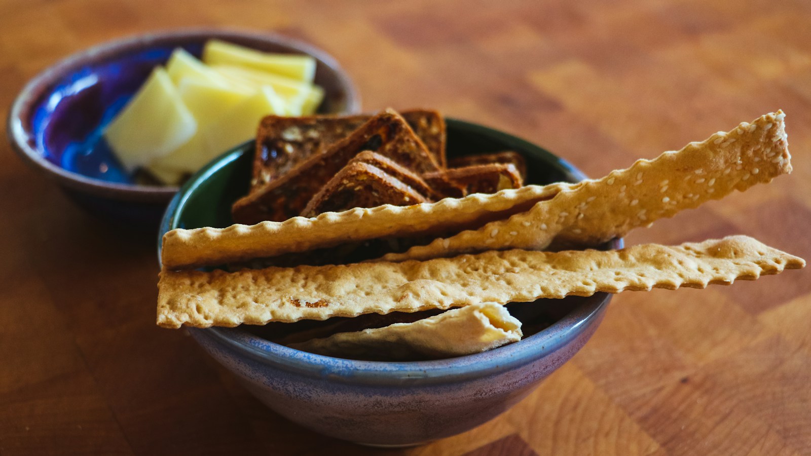 A bowl of crackers served beside butter