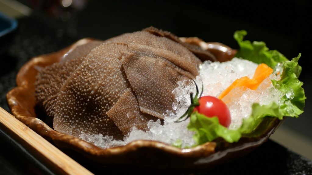 Dark tripe pieces arranged over ice with lettuce