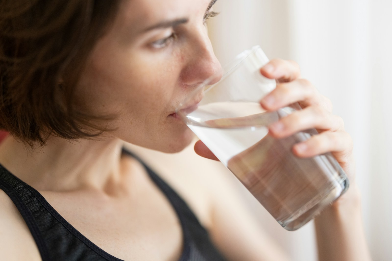 Person drinking from a glass of water