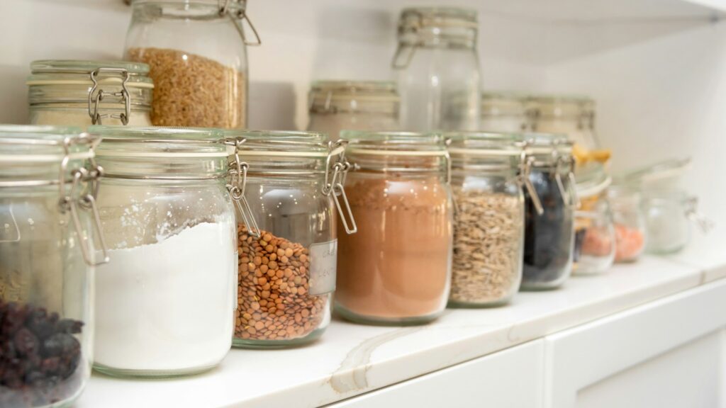 Dry pantry ingredients in sealed glass jars on a shelf