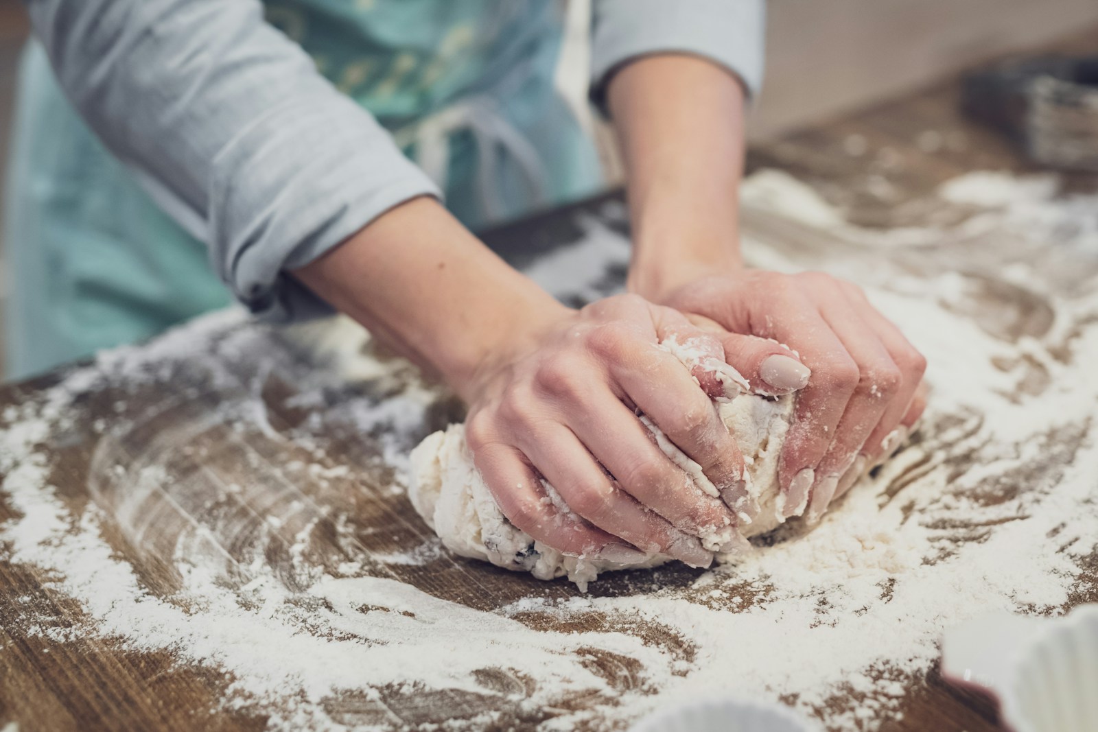Hands working dough on a flour-dusted counter