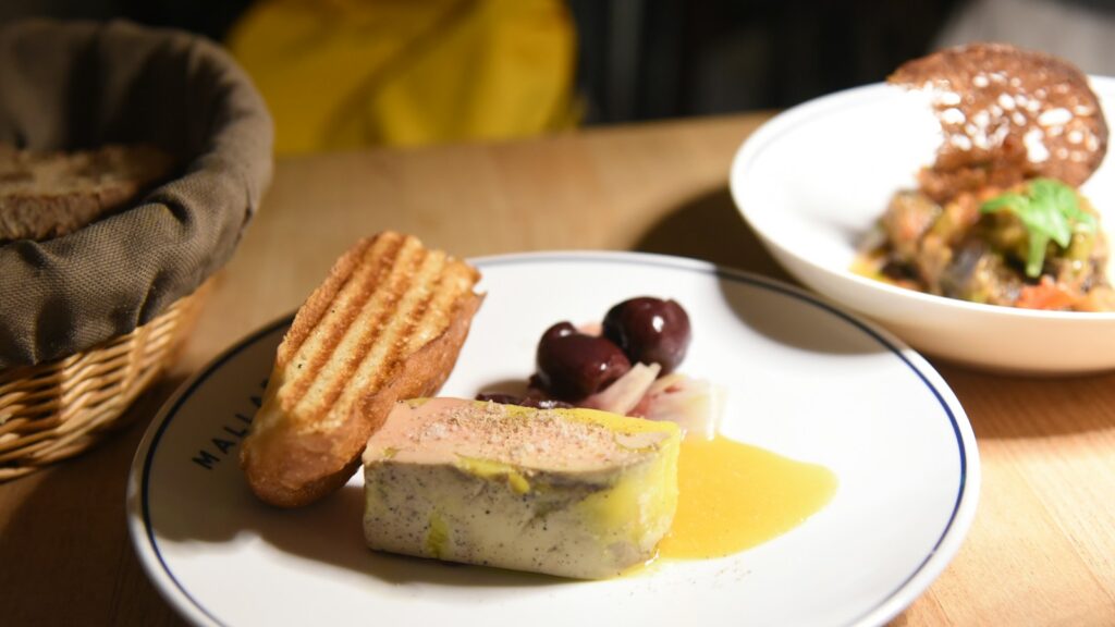 Prepared foie gras with toast and olives on a plate