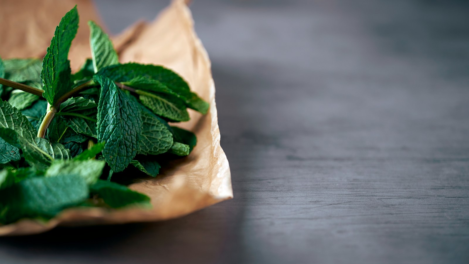 Fresh mint leaves resting on brown paper