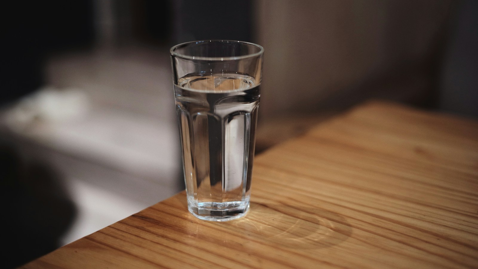 A clear glass of drinking water on a wooden table