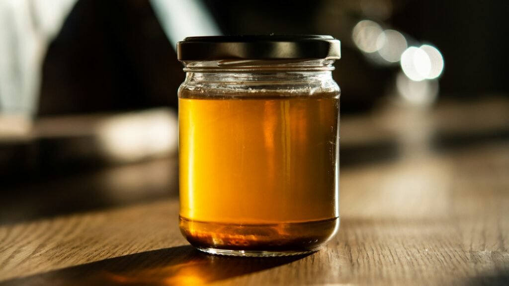 Golden vegetable broth in a clear glass jar