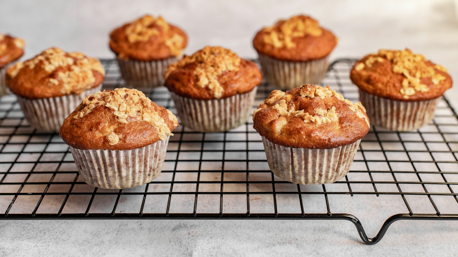 Golden muffins cooling on a wire rack