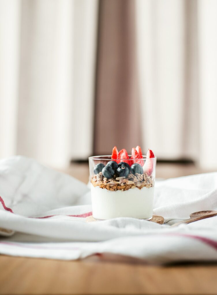 Greek yogurt topped with granola, blueberries, and sliced strawberries