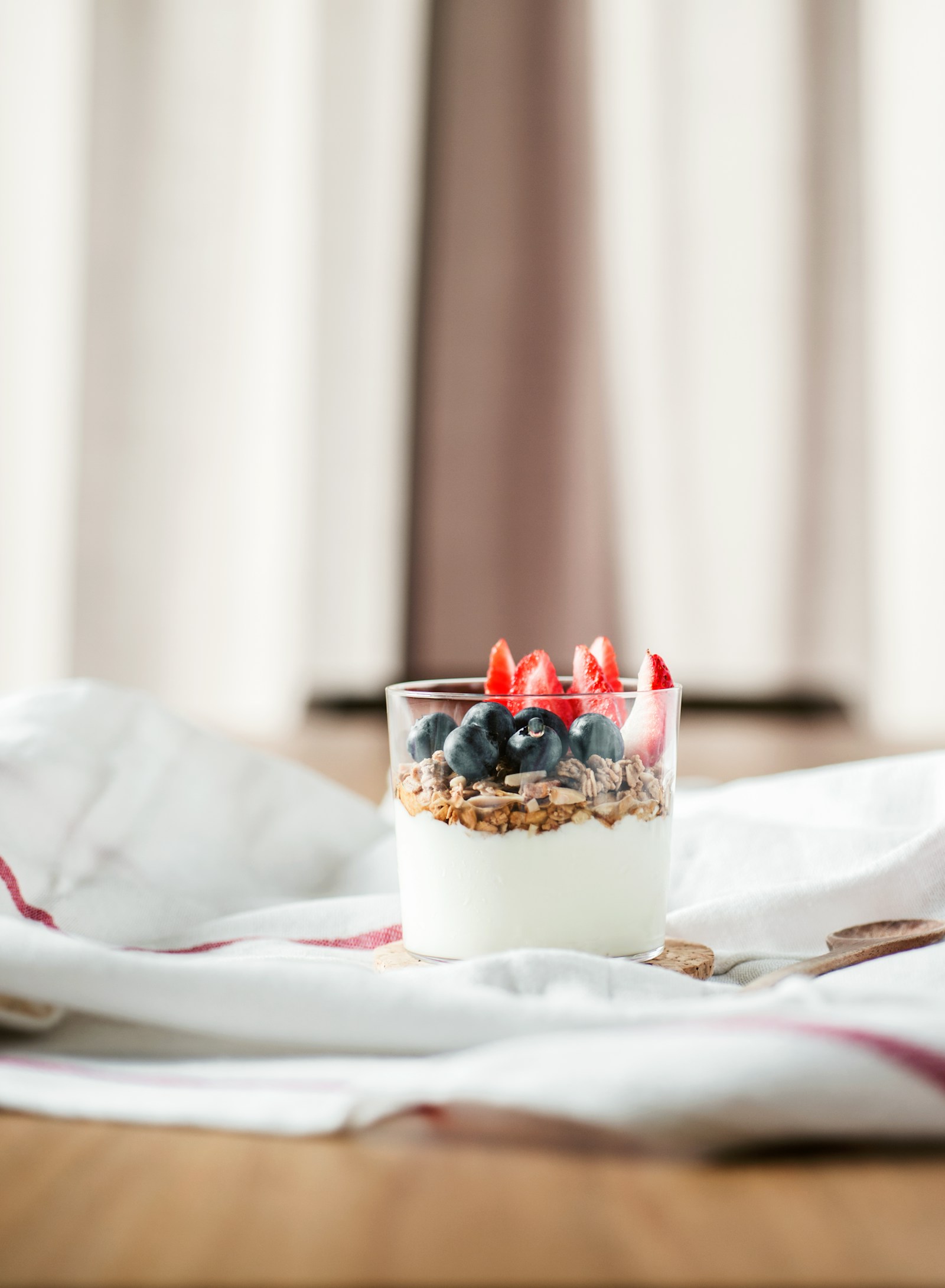 Greek yogurt topped with granola, blueberries, and sliced strawberries