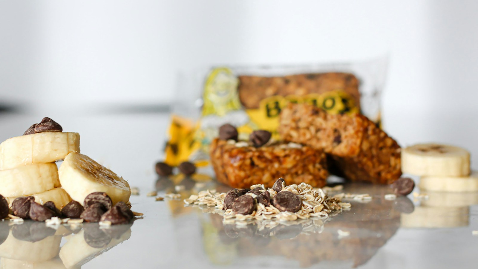 An oat bar beside banana slices and seeds
