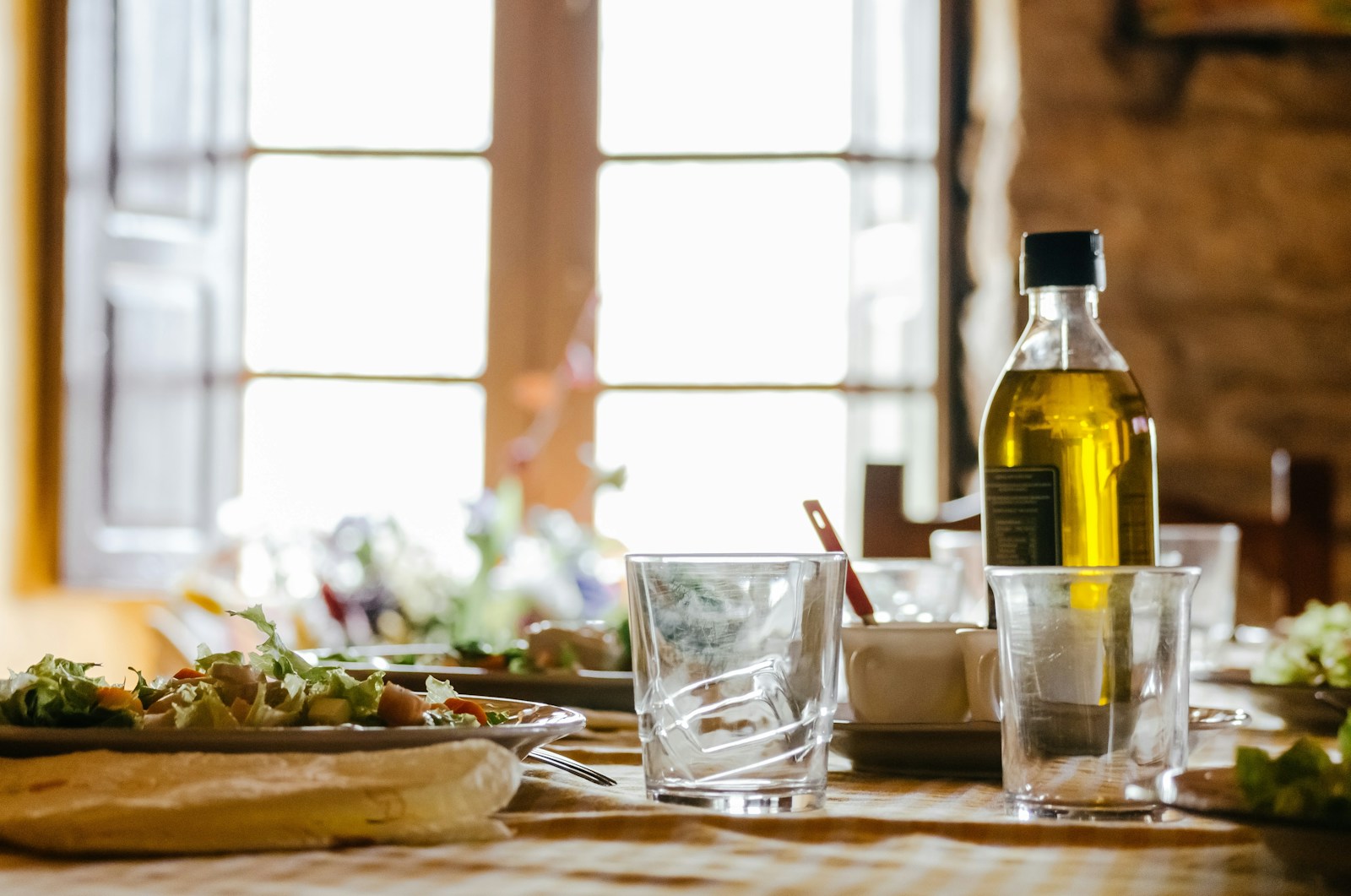 A bottle of olive oil on a dining table