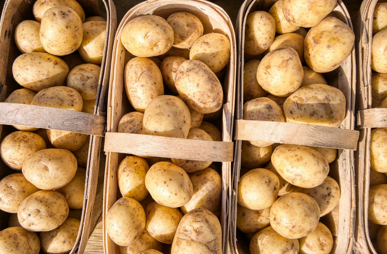 Whole potatoes arranged in wooden market baskets