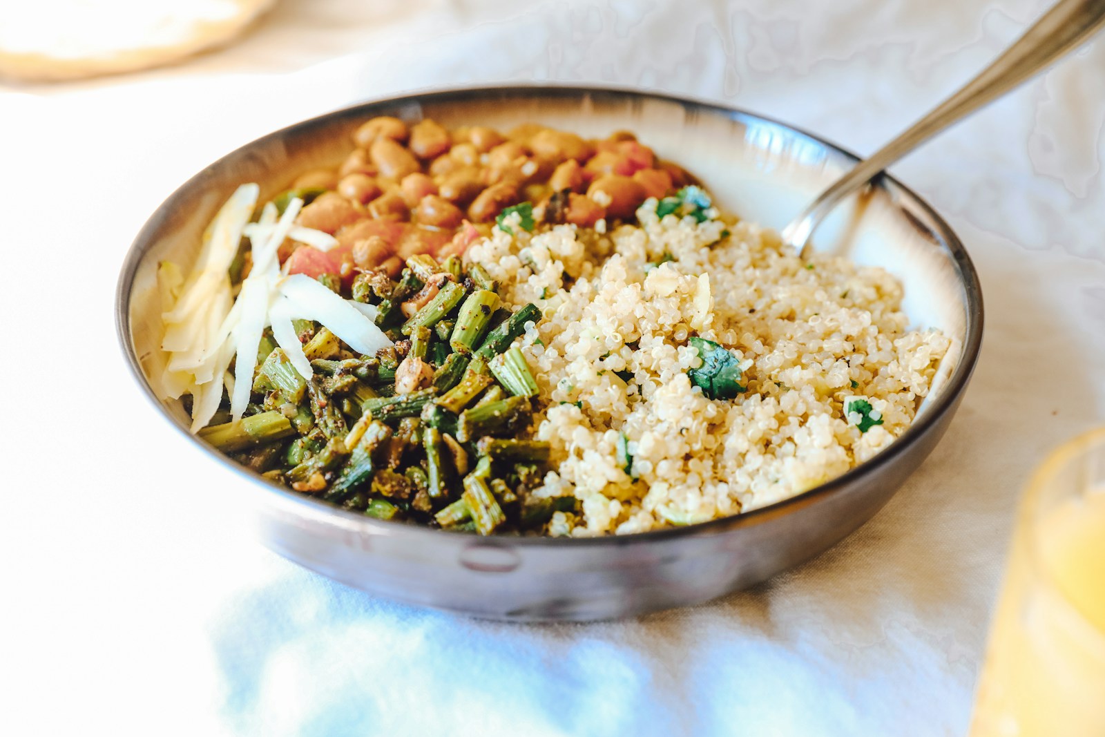 A quinoa meal bowl with beans, asparagus, and vegetables