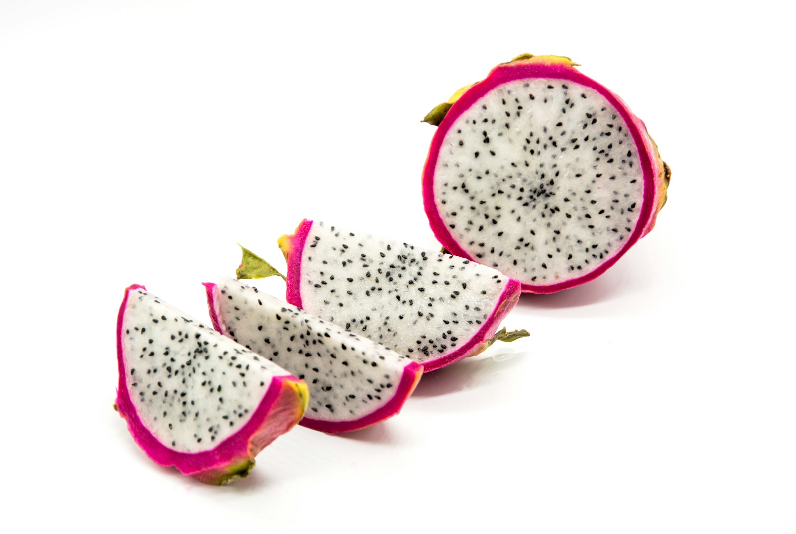 Dragon fruit cut into slices with white flesh and tiny black seeds